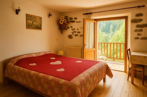 Un dormitorio con una cama con una colcha roja con corazones. en Auberge La Cleida, en Névache