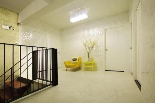 清刊The Royal Chiangkhan Boutique Hotel的一间带楼梯和黄色椅子的客厅