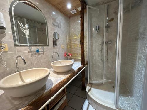 un baño con dos lavabos y una ducha en Auberge La Cleida, en Névache