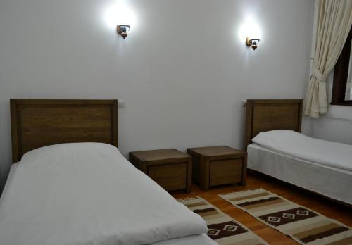 a bedroom with two beds and two night stands at Casa de Oaspeți Sfântul Nicolae in Iaşi