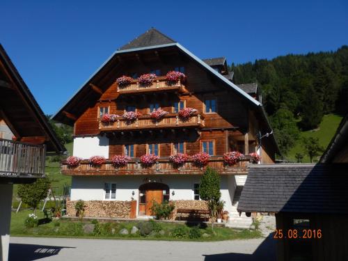 ein großes Gebäude mit Blumenkästen an den Fenstern in der Unterkunft Berghof Thurnergut in Spital am Pyhrn