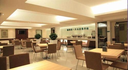 City Comfort Inn Shenzhen Longhua Bus Station Qinghu Metro Station في Tiantangwei: غرفة طعام مع طاولات وكراسي في مطعم