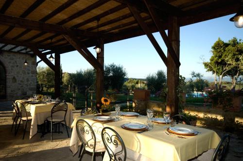 a table with white tables and chairs under a pavilion at Tenuta Decimo - Il Borgo Di Mariano in San Gimignano