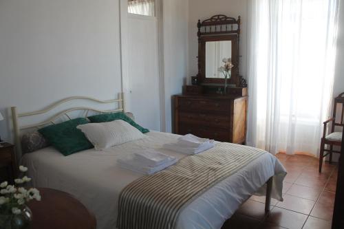 ein Schlafzimmer mit einem Bett mit einer Kommode und einem Spiegel in der Unterkunft Casa do Chafariz in Raminho