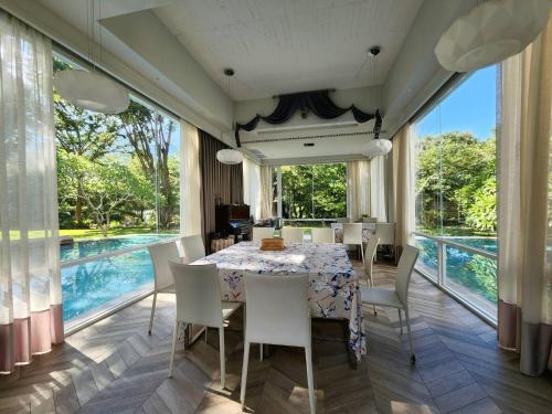 a dining room with a table and chairs and a pool at Around The Tree Manor in Shitan