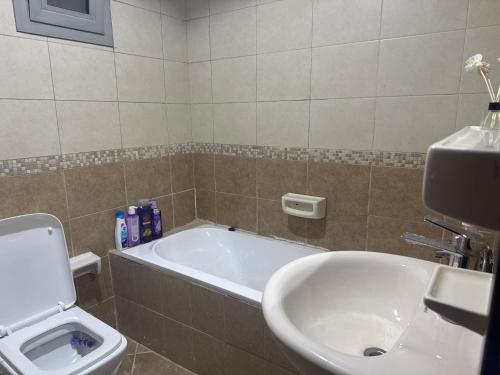 a bathroom with a tub and a toilet and a sink at Helsa private room with attached bathroom in Sharjah