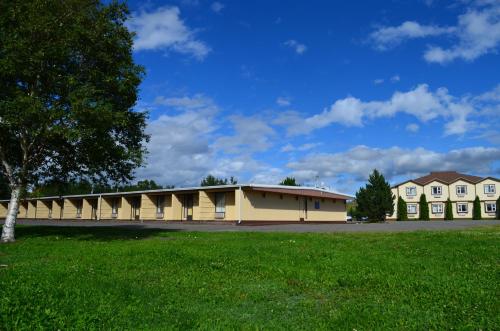 a large building with a green field in front of it at Mount Peyton Resort & Conference Centre in Grand Falls -Windsor