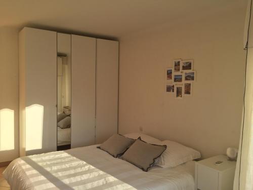 une chambre blanche avec un lit et un miroir dans l'établissement Immeuble le St Honorat, à Cannes