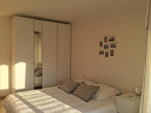 a white bedroom with a bed and a mirror at Immeuble le St Honorat in Cannes