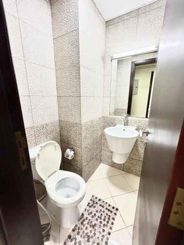 a bathroom with a toilet and a sink at Beachfront Luxury Stay with private beach 2 bedroom in Ras al Khaimah