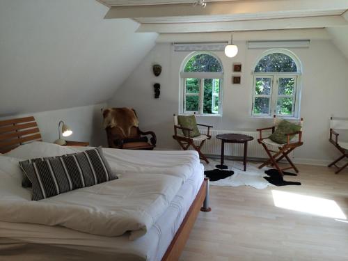 a living room with a white couch and chairs at Kildegaarden Bed & Breakfast in Frørup