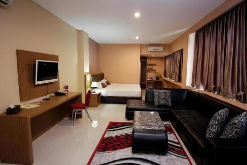 a hotel room with a couch and a bed at Asoka Luxury Hotel in Tanjungkarang