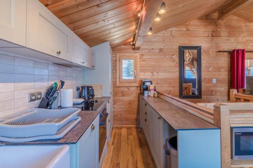una cucina con pareti in legno e piano di lavoro in legno di Cosy 4 bedroom chalet with hot tub (Chalet Velours) a Saint-Marcel