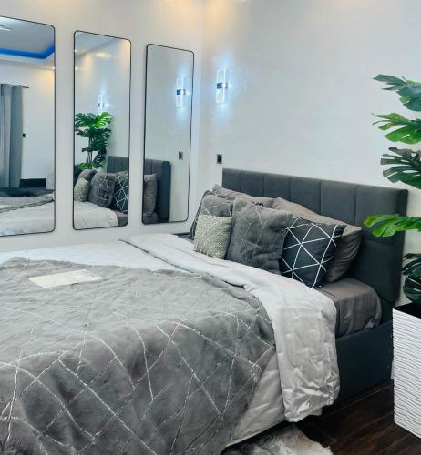a bedroom with a large bed with three mirrors at Club Balai Isabel - Audrey-Adam Staycation Balai in Batangas City