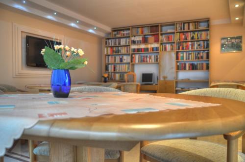 a room with a table with a vase of flowers on it at Panoramic-Oscar in Mrągowo