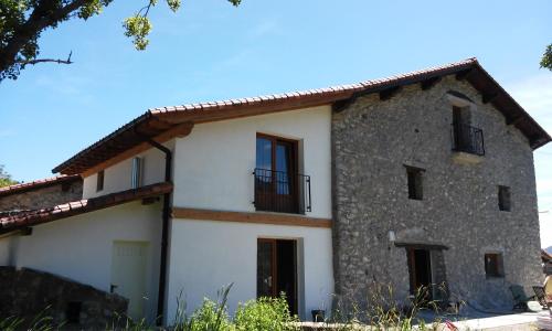 an old stone house with a balcony on top at Agroturismo Erlete Goikoa -ESTAMOS EN EL CAMINO DE SANTIAGO -WE ARE ON THE CAMINO DE SANTIAGO in Deba