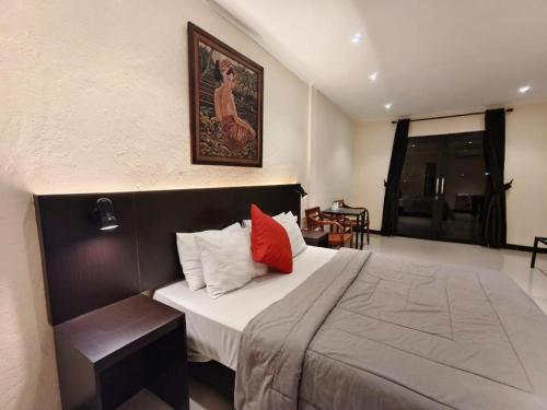 CitepusAugusta Pelabuhan Ratu Hotel的卧室里有一张床，墙上挂着一幅画