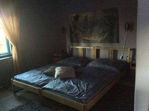 a bedroom with a bed with a blue comforter at Bakancstanya in Kétbodony