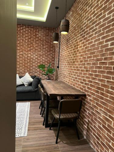 a dining room with a brick wall and a table and chairs at luxury basement studio in Riyadh