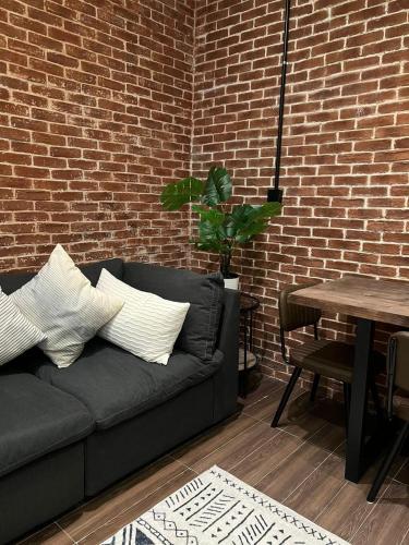 a living room with a couch and a brick wall at luxury basement studio in Riyadh