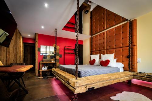 a bedroom with a swing bed and red walls at Les biquettes Amoureuses in Carspach