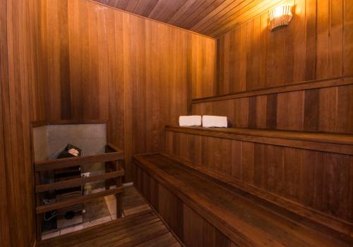 a sauna with wood paneled walls and a fireplace at Transamerica Executive Jardins in Sao Paulo