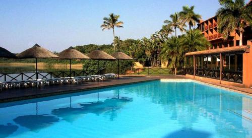 ein großer Swimmingpool mit Liegen und Sonnenschirmen in der Unterkunft San Lameer Villa 2012 in Southbroom