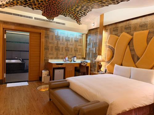 a bedroom with a bed and a desk and a sink at Wei Feng Exquisite Motel Pintung Branch in Pingtung City