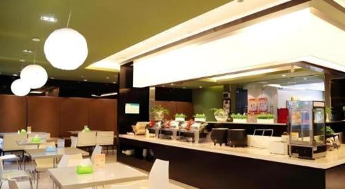 a restaurant with tables and chairs and a large mirror at Jinjiang Inn Xiamen Railway Station in Xiamen