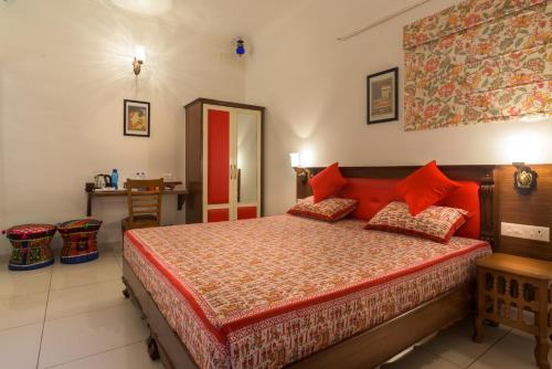 a bedroom with a bed and a dresser at The Coral Court Homestay in Agra