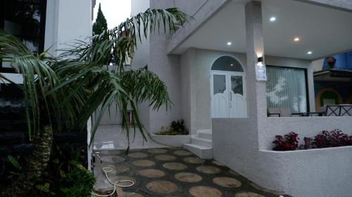 a house with palm trees in front of a door at Villa Dalia Puncak NA6-06 in Cimacan