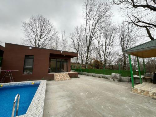 ein Haus mit einem Swimmingpool davor in der Unterkunft Qalaciq Resort House in İsmayıllı