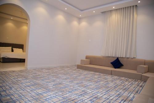 una sala de estar con un sofá y una cama en ديلوكس فخامة مكة, en An Nikāshah