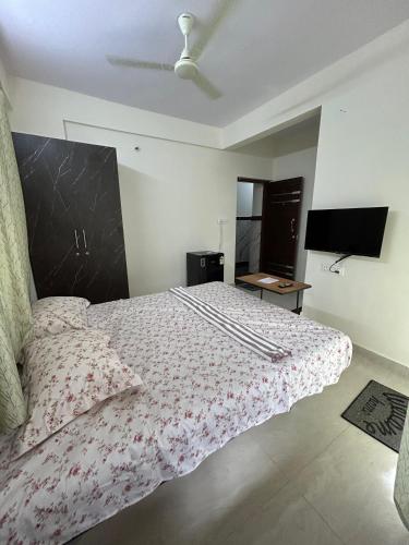 a bedroom with a large bed and a television at Vista inn in Bangalore