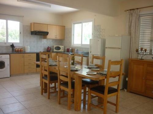 a kitchen with a wooden table and chairs in it at Villa Vista in Paphos