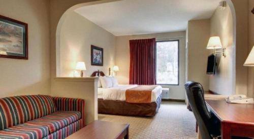 a hotel room with a bed and a couch at Baymont By Wyndham Laurel in Laurel