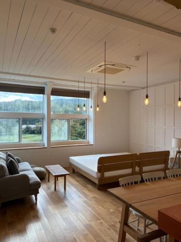 a living room with a bed and a couch at 里山のいぶき舎 in Goto