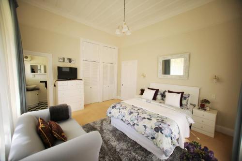 ein Schlafzimmer mit einem Bett, einem Sofa und einem TV in der Unterkunft Regan House in Stratford