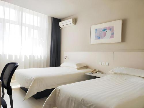 Ένα ή περισσότερα κρεβάτια σε δωμάτιο στο Jinjiang Inn Changchun Pepole Square