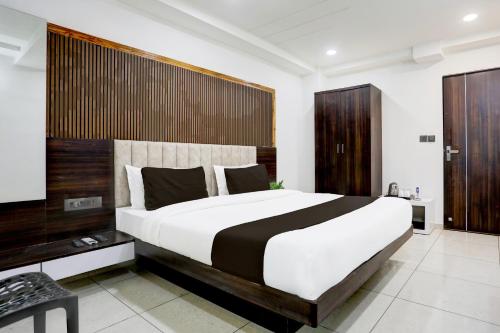 a bedroom with a large bed and a television at Super Hotel O Nana Chiloda Near Airport Formerly Green Valley in Ahmedabad