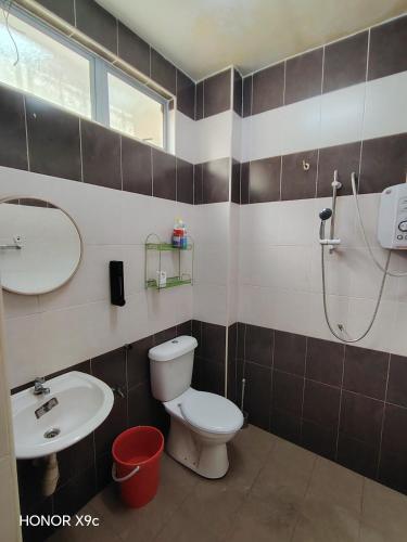 a bathroom with a toilet and a sink and a shower at D'RailHouse65 in Gemas