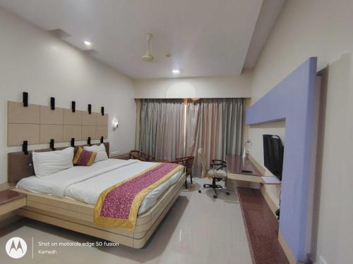 um quarto com uma cama e uma televisão em Townhouse Kakinada Nagamalli Thota Junction em Kākināda