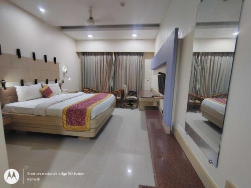 um quarto de hotel com uma cama e uma televisão em Townhouse Kakinada Nagamalli Thota Junction em Kākināda
