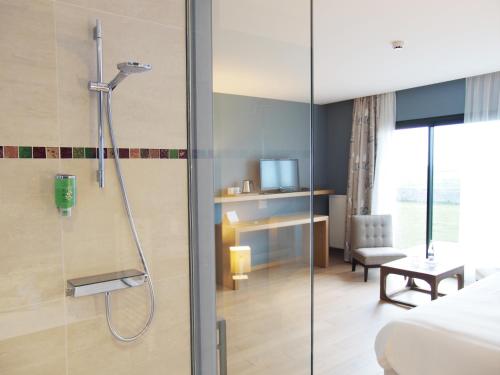 a bathroom with a shower with a glass door at Logis Le Château de Sable in Porspoder