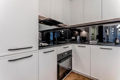 een witte keuken met witte kasten en apparaten bij Apartament Opal Centrum Lublin in Lublin