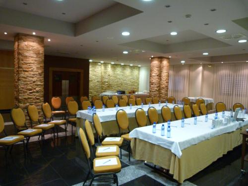 a conference room with tables and chairs in a room at Gran Hotel Ciudad de Barbastro in Barbastro