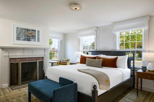 a bedroom with a large bed and a fireplace at Dearborn Inn, Autograph Collection in Dearborn
