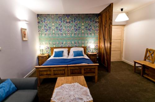 克拉科夫的住宿－Pensjonat Pola，一间卧室配有一张带蓝色床单的床和一张沙发