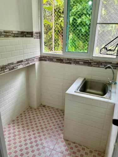 a bathroom with a sink and a window at Takeda - ทาเคดะ in Ban Thok Wak
