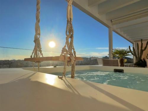 雅典One 360 Skyline Athens Penthouses的泳池里的秋千，背景是阳光